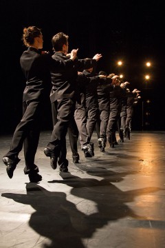 Minus One - dancers in costume doing a figure in a row during a group performance