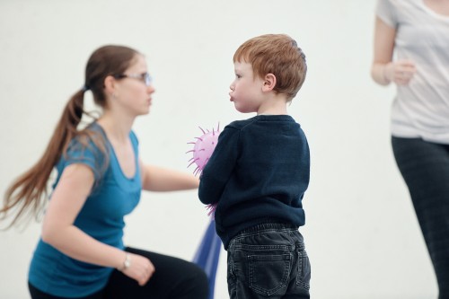 A young boy and a young woman participate in a dance therapy class