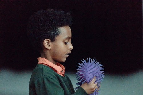 A young boy plays with a sensory ball