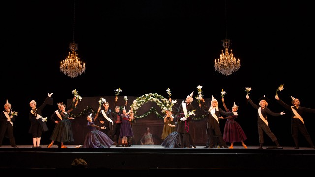 Leonce and Lena - dancers performing a group dance with flowers and suspended chandeliers